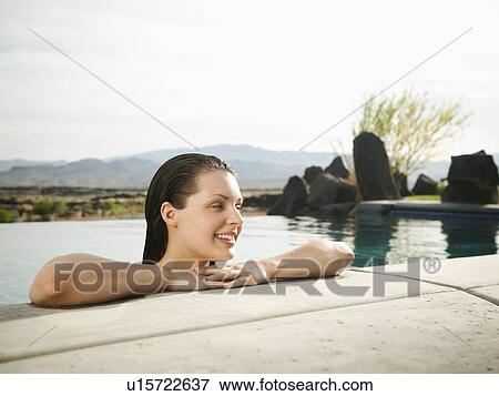 Young attractive woman leaning on edge of swimming pool View Large Photo Image Stock Photo - Young attractive woman leaning on edge of swimming pool. Fotosearch