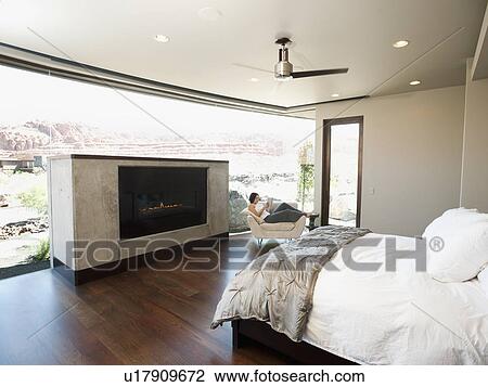 Young attractive woman reading book while sitting in armchair View Large Photo Image Stock Image - Young attractive woman reading book while sitting in armchair. Fotosearch