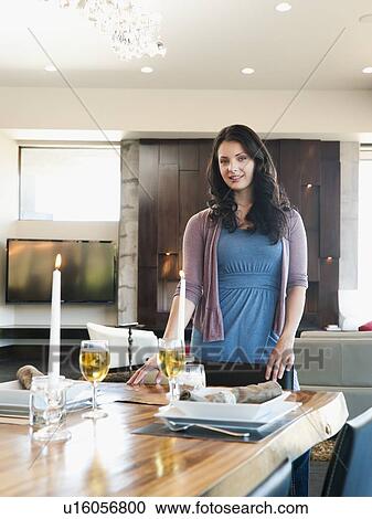 Young attractive woman standing behind table prepared for dinner View Large Photo Image Stock Image - Young attractive woman standing behind table prepared for dinner. Fotosearch