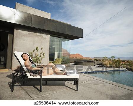 Young attractive woman sunbathing by swimming pool View Large Photo Image Picture - Young attractive woman sunbathing by swimming pool. Fotosearch