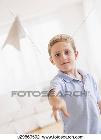 Young boy (6-7) playing with paper plane View Large Photo Image Stock Image - Young boy (6-7) playing with paper plane. Fotosearch