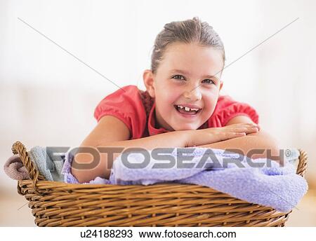 Young girl (8-9) leaning on laundry basket View Large Photo Image Stock Image - Young girl (8-9) leaning on laundry basket. Fotosearch