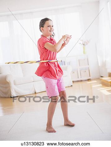 Young girl (8-9) playing with hula hoop View Large Photo Image Stock Image - Young girl (8-9) playing with hula hoop. Fotosearch