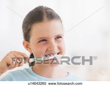 Stock Photography - Young girl brushing her teeth. Fotosearch