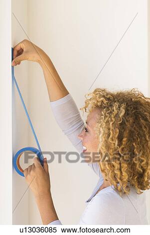 Young woman applying duct tape on wall View Large Photo Image Stock Photography - Young woman applying duct tape on wall. Fotosearch