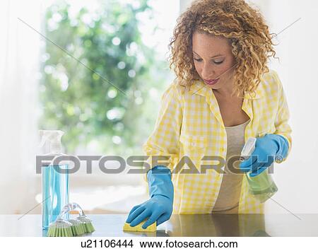 Young woman cleaning in kitchen View Large Photo Image Picture - Young woman cleaning in kitchen. Fotosearch
