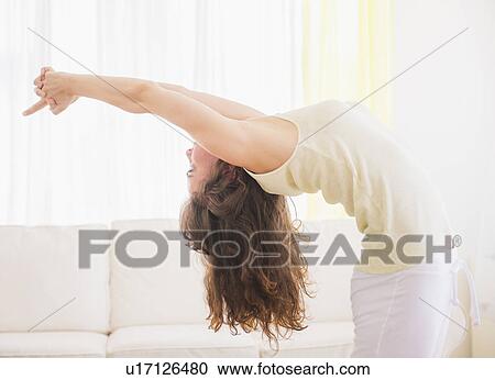 Young woman exercising at home View Large Photo Image Stock Image - Young woman exercising at home. Fotosearch