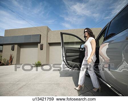 Young woman getting off car View Large Photo Image Stock Photo - Young woman getting off car. Fotosearch