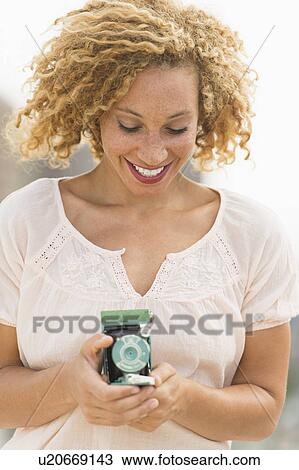 Young woman holding camera View Large Photo Image Stock Image - Young woman holding camera. Fotosearch