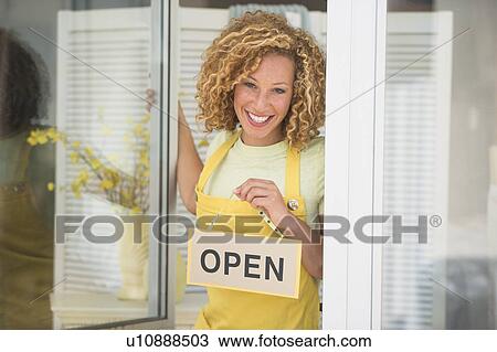 Young woman holding open sign View Large Photo Image Stock Image - Young woman holding open sign. Fotosearch