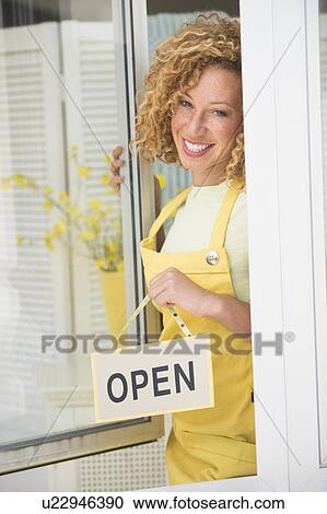 Young woman holding open sign View Large Photo Image Stock Image - Young woman holding open sign. Fotosearch
