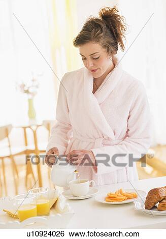 Stock Photograph - Young woman preparing breakfast. Fotosearch