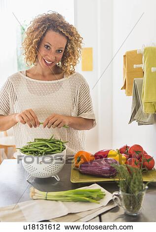 Young woman preparing food in kitchen View Large Photo Image Stock Image - Young woman preparing food in kitchen. Fotosearch