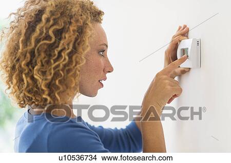 Young woman setting air conditioning View Large Photo Image Picture - Young woman setting air conditioning. Fotosearch