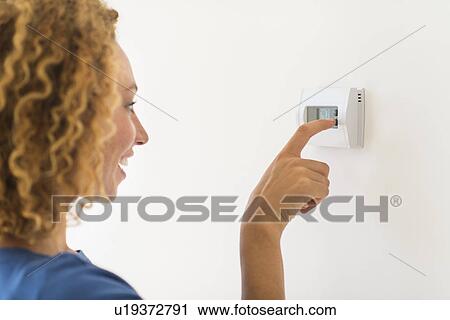 Young woman setting air conditioning View Large Photo Image Stock Image - Young woman setting air conditioning. Fotosearch