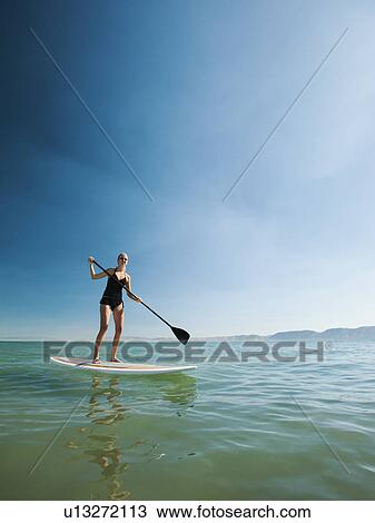 Young woman standing on paddleboard View Large Photo Image Stock Image - Young woman standing on paddleboard. Fotosearch