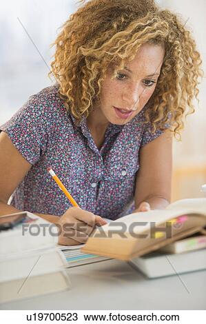 Young woman studying in library View Large Photo Image Stock Image - Young woman studying in library. Fotosearch