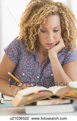 Young woman studying in library View Large Photo Image Stock Image - Young woman studying in library. Fotosearch