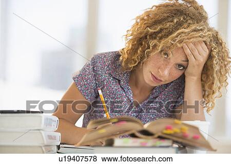 Young woman studying in library View Large Photo Image Stock Photo - Young woman studying in library. Fotosearch