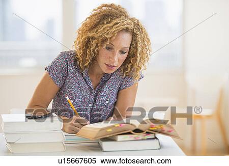 Stock Photography - Young woman studying in library. Fotosearch