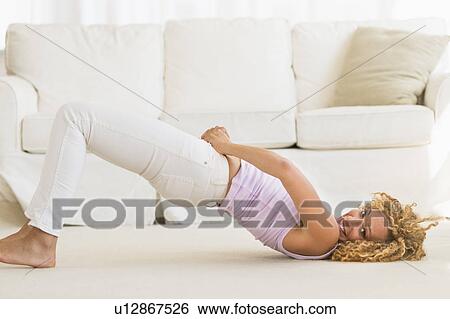 Young woman trying on tight jeans on the floor View Large Photo Image Stock Photograph - Young woman trying on tight jeans on the floor. Fotosearch
