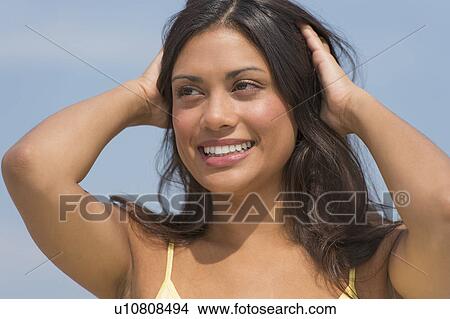 Young woman with hands in hair View Large Photo Image Picture - Young woman with hands in hair. Fotosearch