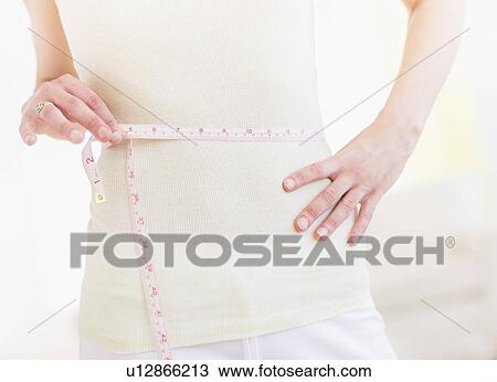 Young woman with tape measure wrapped around waist, midsection View Large Photo Image Stock Image - Young woman with tape measure wrapped around waist, midsection. Fotosearch