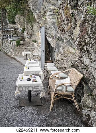 Bar built into stone hillside, with outdoor tables and wicker chairs at San Rocco on path between San Fruttuoso and Camogli, Liguria, Italy View Large Photo Image Stock Image - Bar built into stone hillside, with outdoor tables and wicker chairs at San Rocco on path between San Fruttuoso and Camogli, Liguria, Italy. Fotosearch