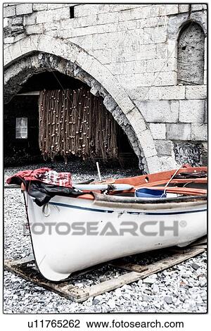 Beach of San Fruttuoso, with view of fishing boat on beach with abbey arches and fishing nets hanging beyond, destaurated image, Camogli, Liguria, Italy View Large Photo Image Stock Image - Beach of San Fruttuoso, with view of fishing boat on beach with abbey arches and fishing nets hanging beyond, destaurated image, Camogli, Liguria, Italy. Fotosearch
