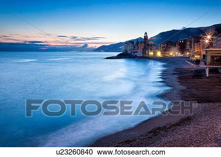 Camogli: beach and sea with motion blur, church tower and sea front buildings, blue twilight sky with dramatic clouds, night lights, Liguria, Italy View Large Photo Image Stock Image - Camogli: beach and sea with motion blur, church tower and sea front buildings, blue twilight sky with dramatic clouds, night lights, Liguria, Italy. Fotosearch