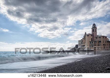Camogli: beach and sea with waves motion blur, church tower and surrounding buildings beyond, blue sky with dramatic clouds, Liguria, Italy View Large Photo Image Stock Photo - Camogli: beach and sea with waves motion blur, church tower and surrounding buildings beyond, blue sky with dramatic clouds, Liguria, Italy. Fotosearch