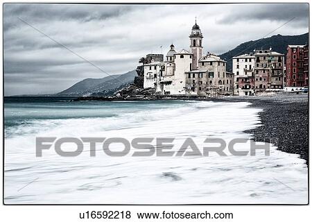 Camogli: beach and sea with waves motion blur, church tower and surrounding buildings beyond, grey sky with dramatic clouds, desaturated image, Liguria, Italy View Large Photo Image Stock Photo - Camogli: beach and sea with waves motion blur, church tower and surrounding buildings beyond, grey sky with dramatic clouds, desaturated image, Liguria, Italy. Fotosearch