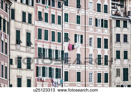 Camogli: sea front apartment buildings painted pink, cream, green with lines of green wooden shutters, and laundry hanging, detail of rectangular patterns, Liguria, Italy View Large Photo Image Stock Image - Camogli: sea front apartment buildings painted pink, cream, green with lines of green wooden shutters, and laundry hanging, detail of rectangular patterns, Liguria, Italy. Fotosearch