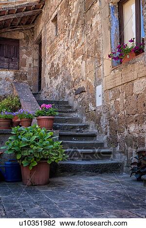 Cività di Bagnoregio: steps surrounded by terracotta planters leading to porticoed doorway of stone house in village, Umbria, Italy View Large Photo Image Stock Image - Cività di Bagnoregio: steps surrounded by terracotta planters leading to porticoed doorway of stone house in village, Umbria, Italy. Fotosearch