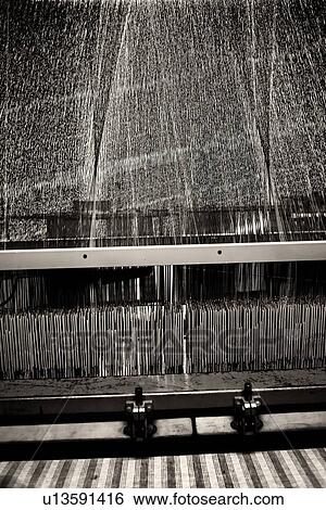 Close up view of Jacquard loom with pattern formed by linen and cotton threads attached to heddle, and fabric emerging below, high key monochrome image, Umbria, Italy View Large Photo Image Stock Photograph - Close up view of Jacquard loom with pattern formed by linen and cotton threads attached to heddle, and fabric emerging below, high key monochrome image, Umbria, Italy. Fotosearch
