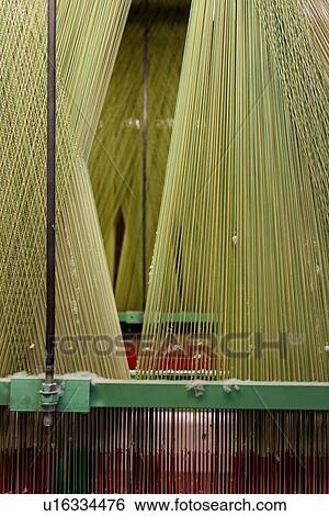 Stock Photograph - Close up view of Jacquard loom with pattern formed by green and red linen and cotton threads attached to heddle, Umbria, Italy. Fotosearch
