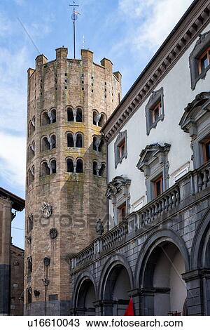 Stock Image - Close up view of twelve-sided Romanesque -Gothic tower of Sant'Andrea, beside the Renaissance Palazzo Comunale, with white stucco, ornate grey framed windows, Orvieto, Umbria, Italy. Fotosearch
