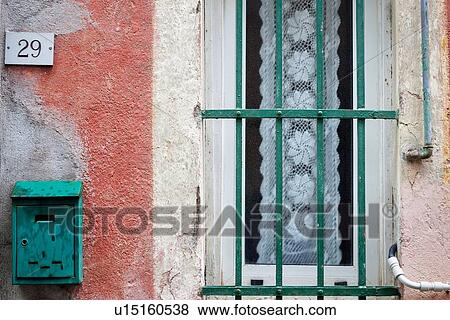 Closeup view of heavily textured pink wall, green letter box, and green metal window railings with white lace hangin behind frosted glass, Monterosso al Mare, Cinque Terre, Liguria, Italy View Large Photo Image Stock Photo - Closeup view of heavily textured pink wall, green letter box, and green metal window railings with white lace hangin behind frosted glass, Monterosso al Mare, Cinque Terre, Liguria, Italy. Fotosearch
