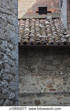 Stock Photo - Detail of adjacent stone walls of houses, with traditional red tiled terracotta tiles on roofed area, medieval village, Umbria, Italy. Fotosearch