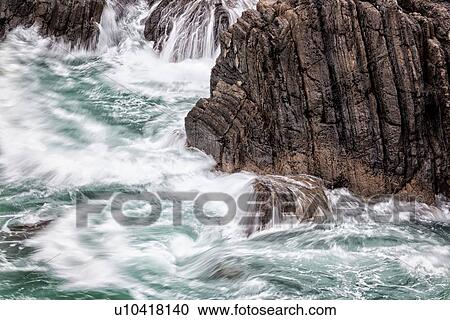Stock Image - Detail of heavy seas smashing against rocks, with motion blur, Cinque Terre, Italy. Fotosearch