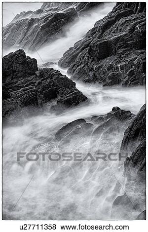 Stock Photo - Detail of heavy seas smashing against rocks, with motion blur, monochrome image, Cinque Terre, Italy. Fotosearch