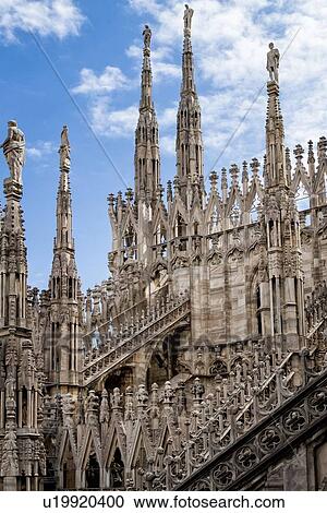 Detail of Milan Duomo rooftop: series of rooftop pinnacles and flying buttresses, elaborate stone carving, against sky, Milan Italy View Large Photo Image Stock Image - Detail of Milan Duomo rooftop: series of rooftop pinnacles and flying buttresses, elaborate stone carving, against sky, Milan Italy. Fotosearch