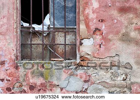 Detail of old derelict warehouse: crumbling pink and red stucco wall, broken window with rusty metal grate, Emilia Romagna, Italy View Large Photo Image Picture - Detail of old derelict warehouse: crumbling pink and red stucco wall, broken window with rusty metal grate, Emilia Romagna, Italy. Fotosearch