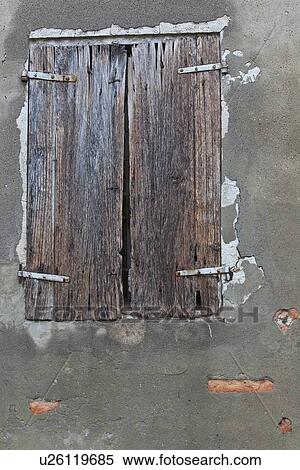 Stock Photography - Detail of old stucco house with crumbling facade, ancient wooden shutter over window, typical style, Emilia Romagna, Italy. Fotosearch