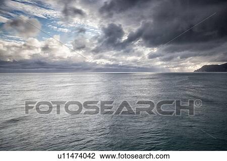 Dramatic sky at sunset with storm approaching coastline, clouds and sea lit by sunlight, Manarola, Cinque Terre, Liguria, Italy View Large Photo Image Stock Image - Dramatic sky at sunset with storm approaching coastline, clouds and sea lit by sunlight, Manarola, Cinque Terre, Liguria, Italy. Fotosearch