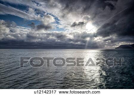 Stock Photo - Dramatic sky at sunset with storm approaching coastline, clouds and sea lit by sunlight, Manarola, Cinque Terre, Liguria, Italy. Fotosearch