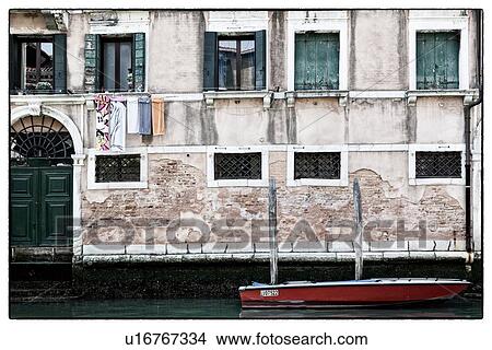 Facade of palace in front of canal, laundry hanging under green shuttered windows, red boat moored in front, Venice, Italy View Large Photo Image Picture - Facade of palace in front of canal, laundry hanging under green shuttered windows, red boat moored in front, Venice, Italy. Fotosearch