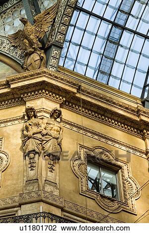 Gallerica Vittorio Emanuele: close up detail view of central mall area ceiling, glass and cast iron arched roof with stone carving statues, Milan Italy View Large Photo Image Stock Image - Gallerica Vittorio Emanuele: close up detail view of central mall area ceiling, glass and cast iron arched roof with stone carving statues, Milan Italy. Fotosearch