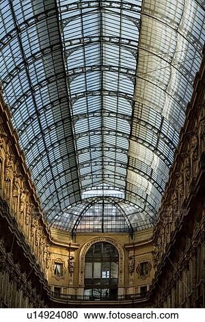 Stock Image - Gallerica Vittorio Emanuele: detail view of central mall area ceiling, glass and cast iron arched roof with stone carving decoration, Milan Italy. Fotosearch
