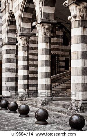 Picture - Genoa Centro Storico: black and white striped arched portico of Piazza Matteo with columns, cannonballs in front, monochrome detail, Genova, Italy. Fotosearch
